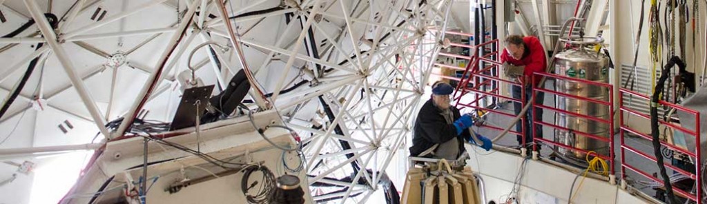 Two men working on a satellite